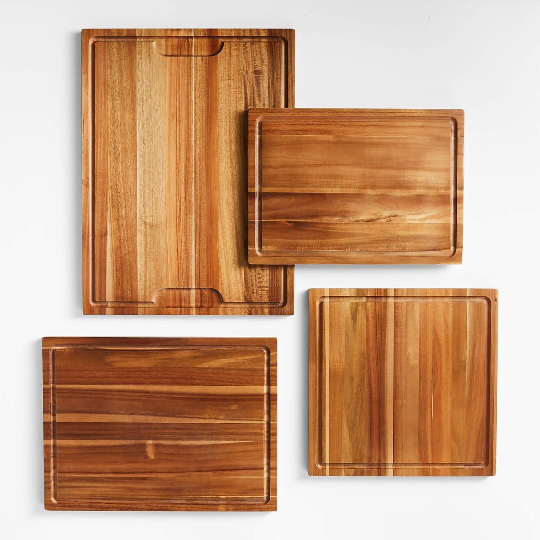 Four wooden cutting boards of different sizes arranged on a white surface.