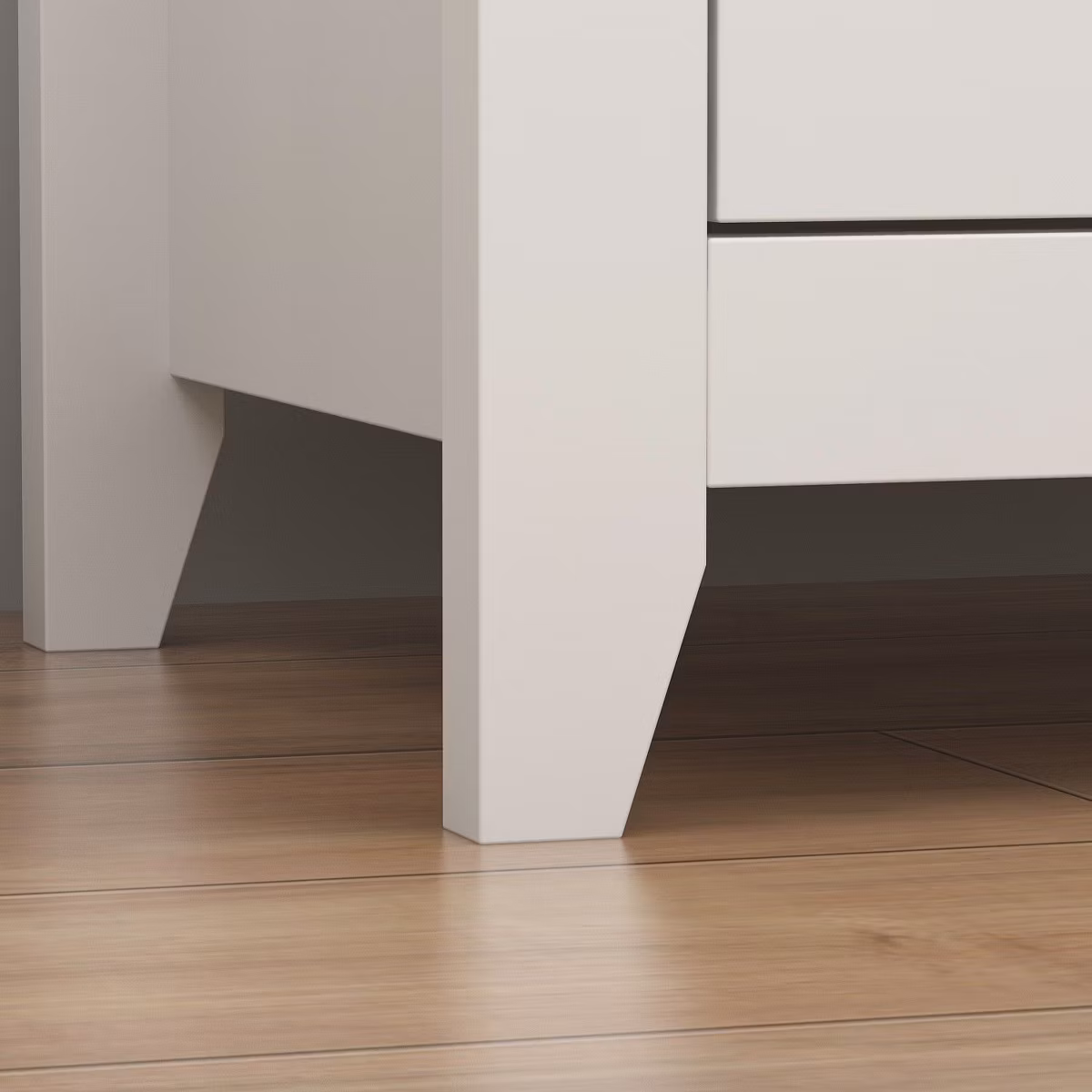 Close-up of white dresser legs on wood floor